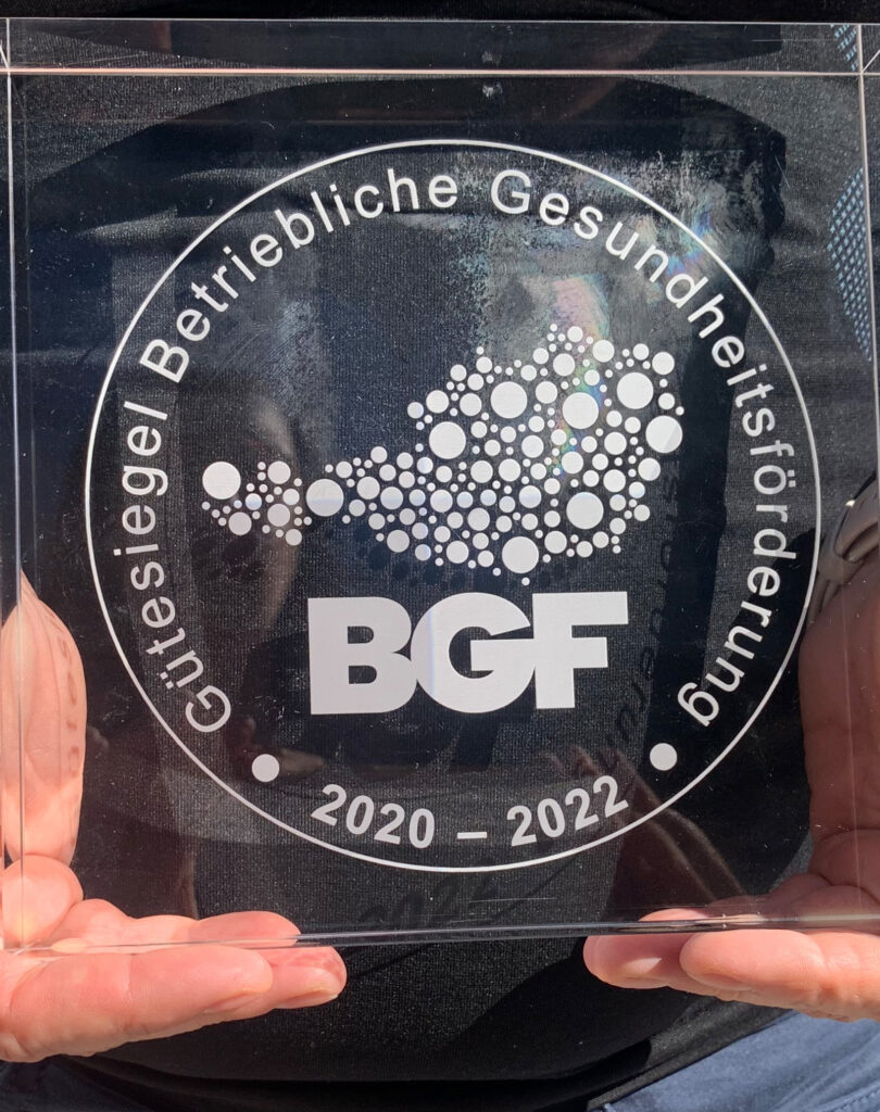 Frau hält BGF-Auszeichnung in der Hand